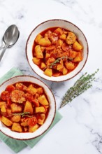 Meat goulash with potatoes and carrots, sweet peppers, in a saucepan, top view, traditional