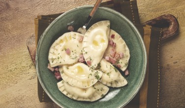 Dumplings, with fried prosciutto, a traditional dish of Polish cuisine, dumplings, top view,