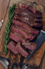 Fried steak, beef steak, rib eye steak, sliced steak, on a chopping board, top view, no people