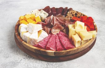 Assortment of cheese meat cuts, on a plate, top view, no people