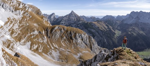 Female hiker standing on a rock and looking into the valley, hiking to Gamsjoch, down the