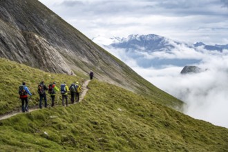 Hikers in front of a sea of clouds in the mountains, Hohe Tauern National Park, Carinthia, Austria