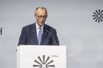 Federal Chancellor Friedrich Merz (CDU) . Portrait at the lectern with free text space.