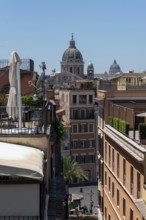 Row of houses in Rome on several church domes, including in the background the dome of St. Peter's