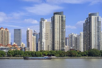 View over the Huangpu River and skyline showing skyscrapers and high-rise flats in the Pudong