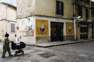 Woman with stroller, wall painting, advertisement, 1950s, corner house with old advertisement,