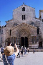 Woman with sunhat photographs St. Trophime Cathedral, Arles, France
