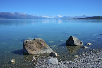 Large stones on clear lakeside with mountains in the background, Lake Pukaki Viewpoint, Pukaki,