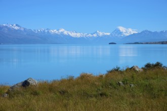 View over grassy shores to mountains across the lake, Lake Pukaki Viewpoint, Pukaki, Canterbury,
