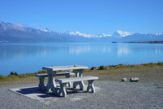 A lakeside picnic table with views of snow-capped mountains and calm water, Lake Pukaki Viewpoint,