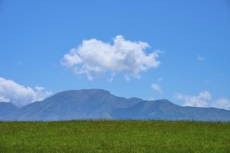 Green field with distant mountains and a cloud in the blue sky, Geraldine Fairlie Lookout,