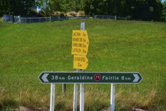 Road signs with distances on green background in rural area, Geraldine, Canterbury, South Island,