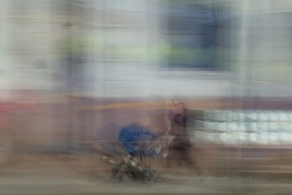 Abstract image of a woman pushing a pram in city captured using ICM intentional camera movement