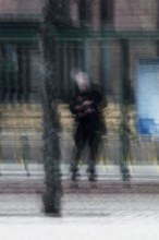 Abstract of a man waiting for bus under bus stop shelter captured using ICM intentional camera
