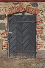 Closed old black door on a red brick wall, Karjalohja, Finland