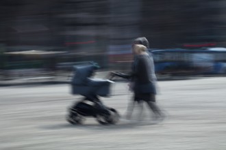 Abstract image of a couple pushing a pram in city captured using ICM intentional camera movement