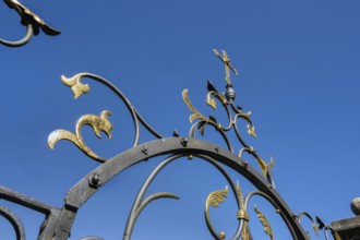 Blue sky and wrought iron gate to the cemetery in Maria-Thann, Allgäu, Swabia, Bavaria, Germany