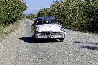 American classic car from the 1950s, near Holguin, Cuba, vintage classic car driving on a rural