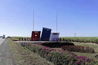 Sign with the word 'Santiago de Cuba' on a field with blue sky, Cuba, Greater Antilles, Caribbean,