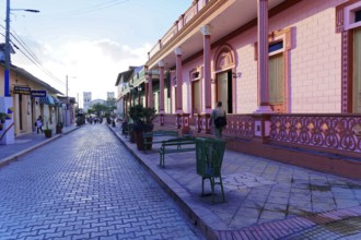 Baracoa, Cuba, Central America, colorful colonial buildings and a paved street under a clear sky,
