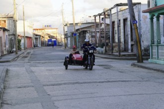 Baracoa, Cuba, Central America, morning scene in quiet street with motorcycle team and sidecar,
