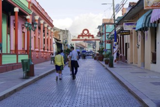 Baracoa, Cuba, Central America, people walking on a street lined with colonial buildings, Greater
