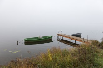 Two boats and a jetty in autumnal, foggy surroundings, Hopfensee, Ostallgäu, Bavaria, Germany