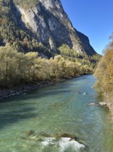 A lively river flows between steep mountains, surrounded by autumn leaves, Drau, Drauradweg, near