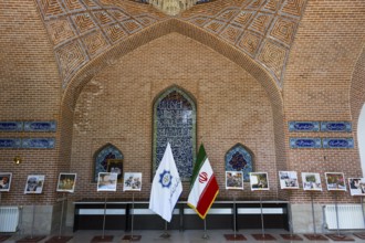 Interior with brick arch and exhibited photos with flags, Blue Mosque, Shiite Mosque, symbol of