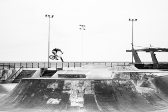 Young man jumping with a bicycle at Skatepark, in Playa Brava. Iquique, Tarapaca Region, Chile