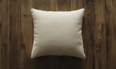 A white pillow sits on a wooden surface. The pillow is unmade and has a simple design. The wooden
