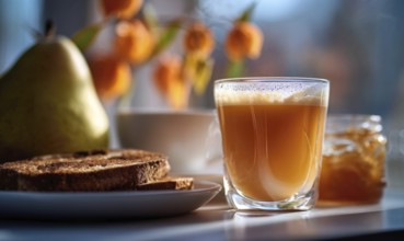 A glass of tea sits on a table next to a plate of toast and a jar of jam. Concept of comfort and