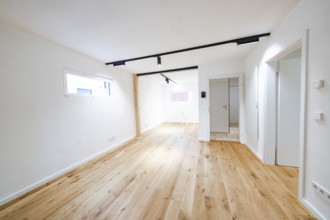Bright living room with oak flooring and black track lights in a modern, reduced design, house