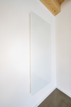 Large white glass wall panel in a bright room with wooden beam ceiling, house renovation, energy