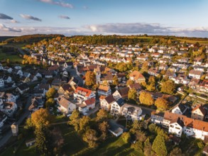 A picturesque village with colorful roofs and autumn trees under a blue sky, Deufringen, Aidlingen,