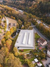 Sports hall nestled in autumn colors and surrounded by river and village road, Walter Lindner