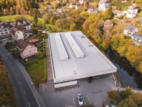 Sports hall in autumn surroundings with colorful trees and adjacent street, Walter Lindner