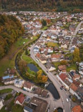 Aerial view of a city with river course and park area, nestled in autumn surroundings, Calmbach,