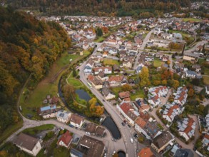 Drone view of an urban landscape with park and watercourse in picturesque autumn scenery, Calmbach,