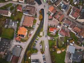 Aerial view of a village from above, showing roads, houses, a river and autumn trees, Calmbach, Bad
