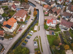 Urban aerial view of an area with a river, parked cars and lush autumn leaves, Calmbach, Bad