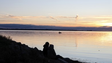 A couple sitting on the beach during sunset, Fehmarn island, 18.10.2025, Fehmarn,