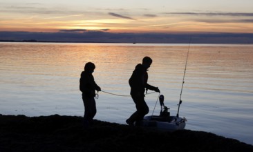 Anglers on the beach during sunset, Fehmarn Island, 18.10.2025, Fehmarn, Schleswig-Holstein,