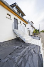 Straight-lined entrance with metal railing and dark door, functional and functional design, house