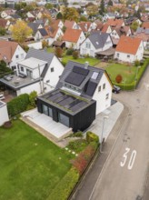 Aerial view of a house on a Tempo 30 road with PV on the roof and a green extension, with a