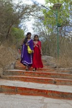Young Indian woman on the red steps to Chamundi Hill, Mysore or Mysore, Karnataka, India