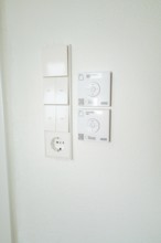 Wall panel with light switches, power outlet and smart home control in simple white, house
