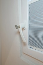 Detail of a white window handle with integrated blind, clean and modern, house renovation, climate