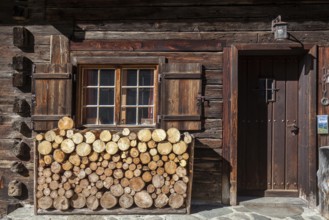 Sawn firewood in front of an old wooden house, Oberallgäu, Allgäu, Bavaria, Germany