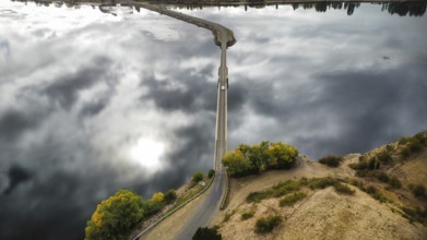 A long bridge over a shallow and calm lake on a cloudy day, photographed with a drone